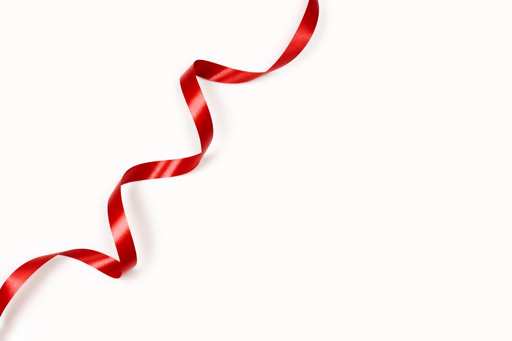 A single red ribbon on the white background with copy space