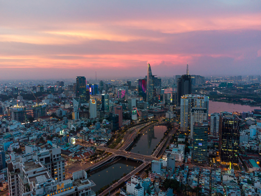 Aerial Drone Photo of District 1 with Reflection of Bitexco Financial Tower in Saigon River at Sunset in Ho Chi Minh City, Vietnam