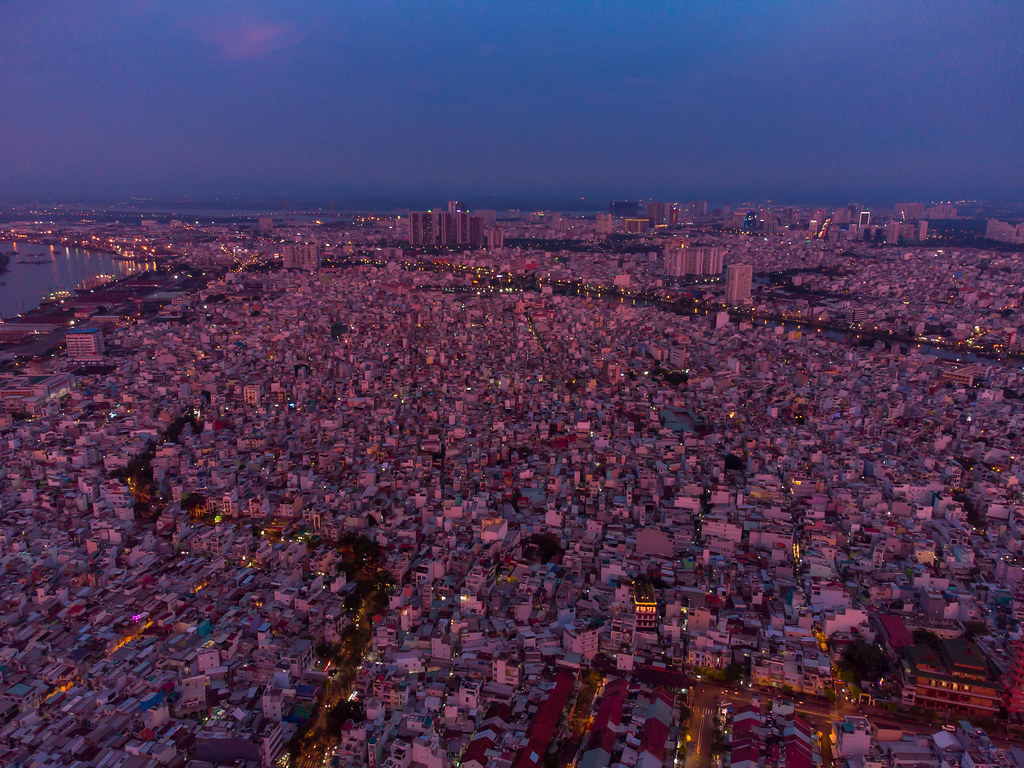 Aerial Drone Photo of many small Houses and Streets in District 4 in the Evening with Khanh Hoi Nha Rong Port at Saigon River in the Background in Ho Chi Minh City, Vietnam