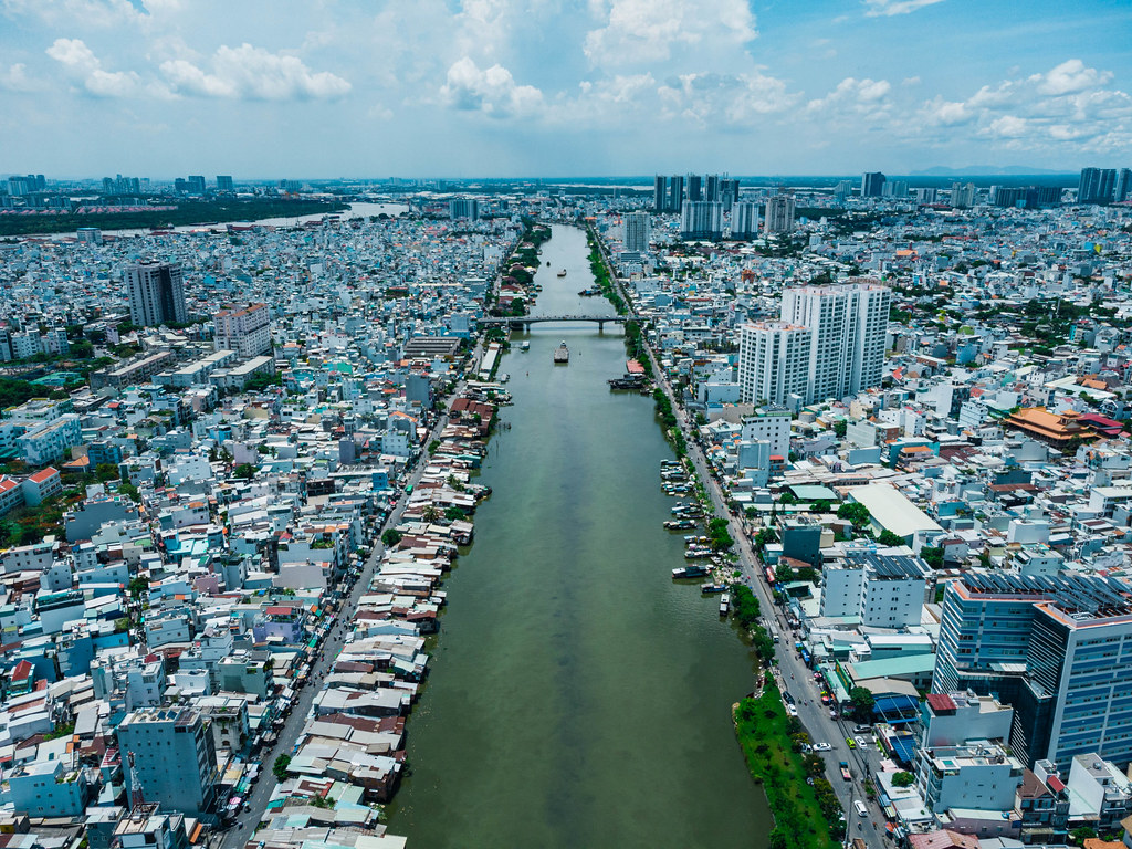 Aerial Drone Photo of Ships on Saigon River along local Houses and Neigborhoods with a View to District 2 in Ho Chi Minh City, Vietnam