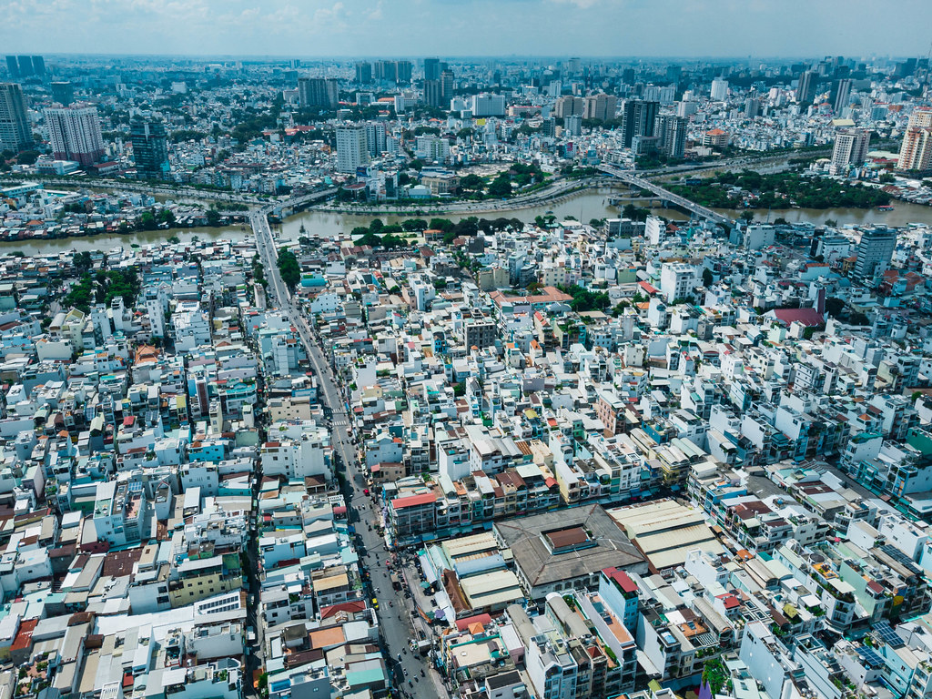 Aerial Drone Shot of many Houses, Schools and Markets along Streets and Bridges over Saigon River in Ho Chi Minh City, Vietnam