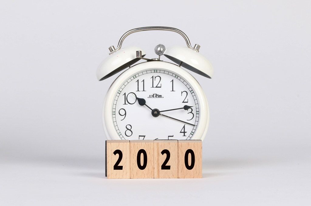 Alarm clock with 2020 text on wooden blocks