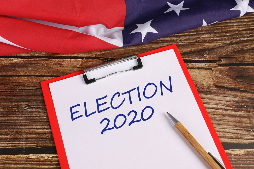 American flag on wooden table with Election 2020 text