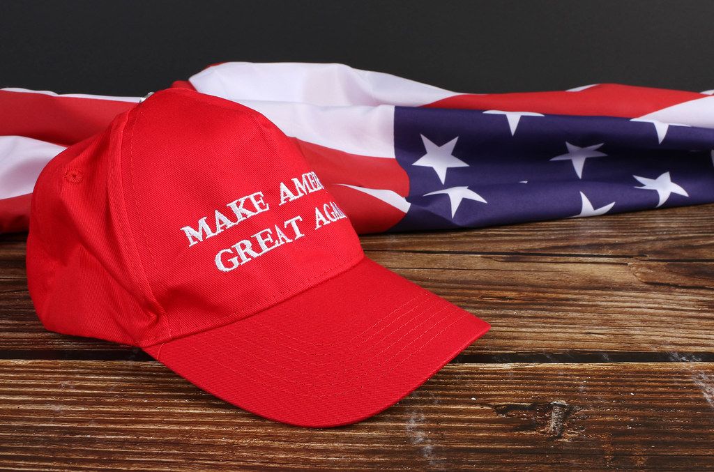 American flag on wooden table with Make America Great Again hat
