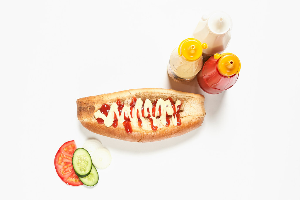 American hot dog with ketchup and mustard on white background