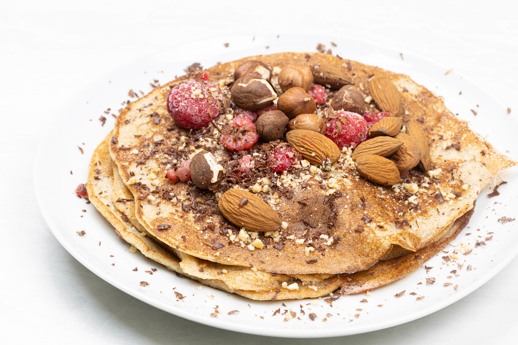 American Pancakes served with almonds raspberries and dark chocolate
