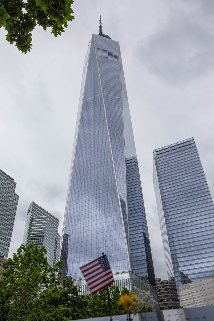 Amerikanische Flagge und Blumen vor dem neuen One World Trace Center, das größte Gebäude in den USA