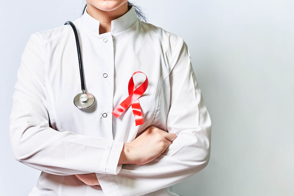 An oncologist with a red ribbon - a symbol of world cancer day