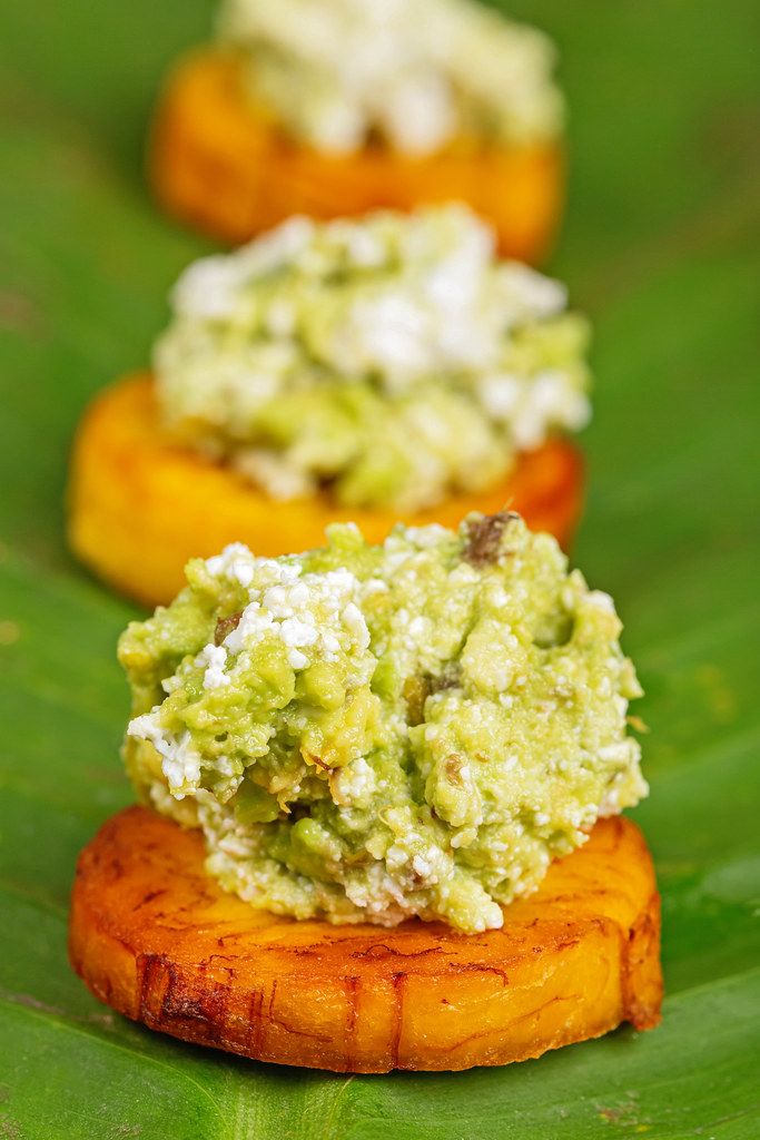 Appetizer with avocado and plantain on a green leaf, close-up
