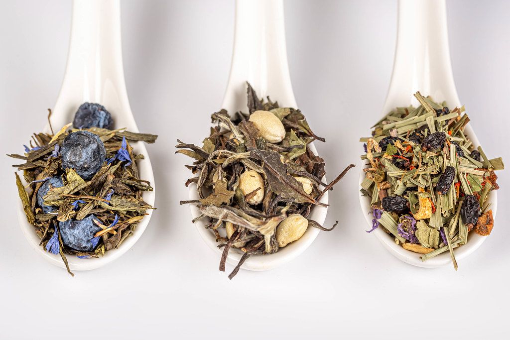 Assortment of fruit green dry teas in spoons, top view