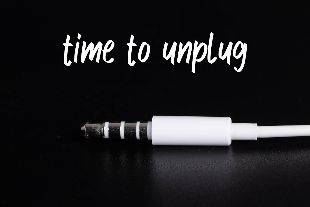 Audio mini jack cable isolated on black with Time to unplig text