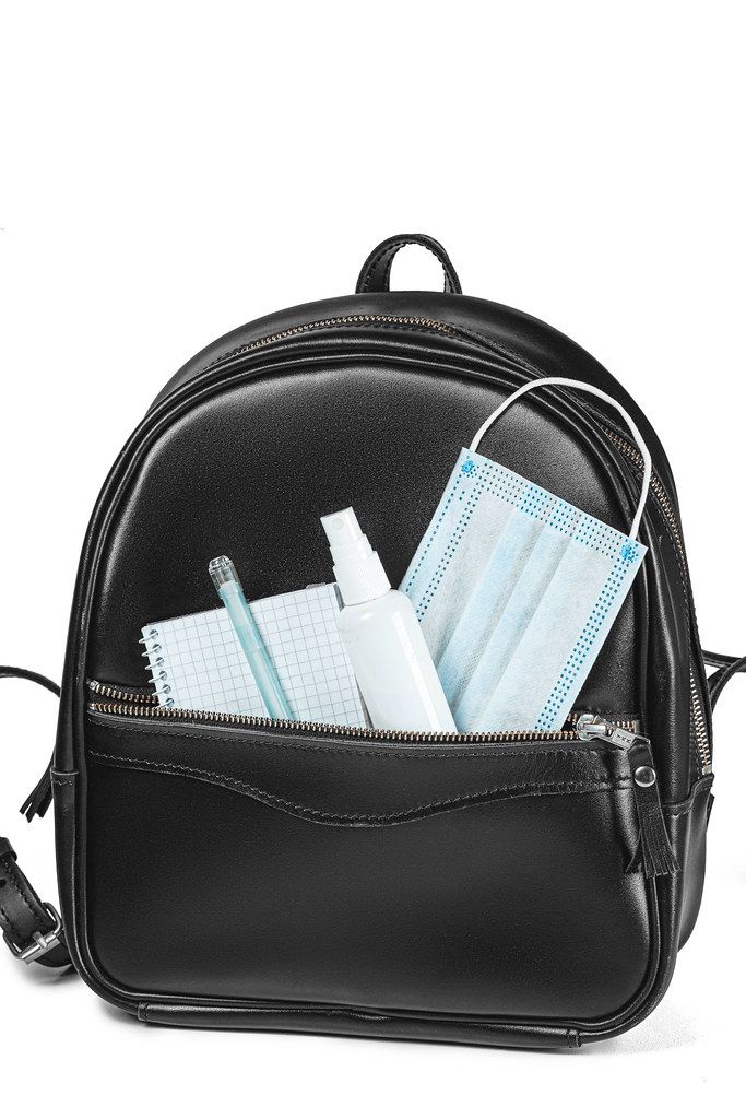 Back to school after quarantine concept. Backpack with school supplies and sanitizer and medical protective mask