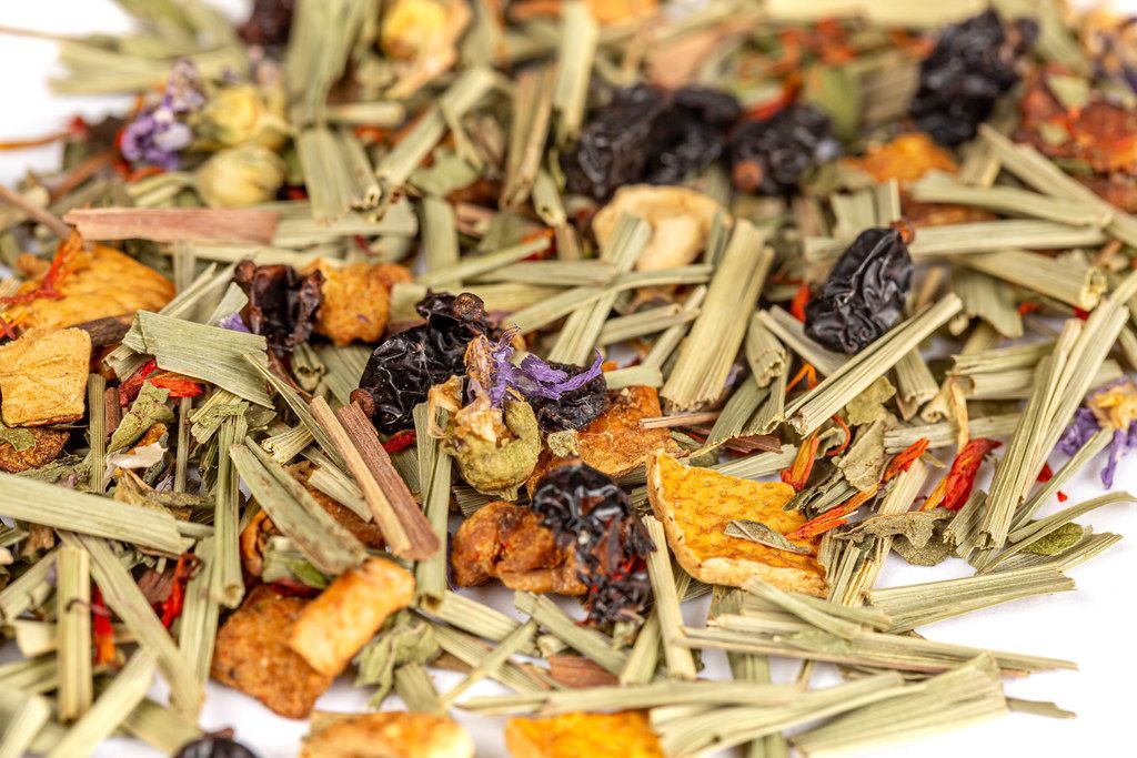 Background of dried tea with pieces of apple, orange, berries of barberry and saffron
