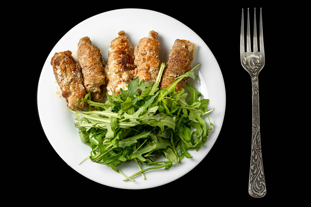 Baked meat rolls stuffed with cheese and arugula, top view