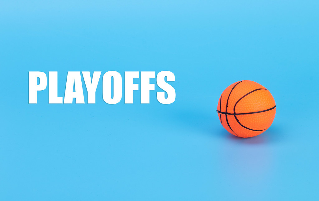Basketball ball and Playoffs text on blue background