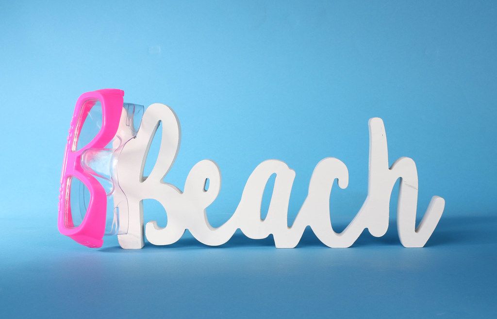 Beach text with diving mask on blue background