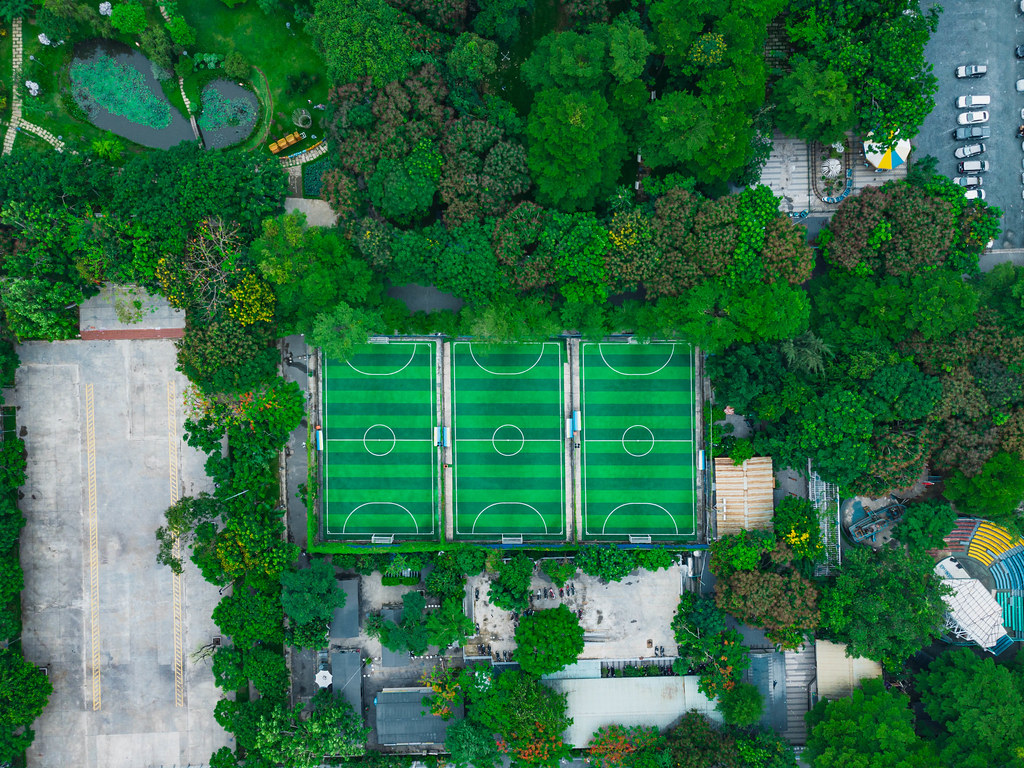 Bird View Drone Photo of three Football Courts within a Public Park with many Trees and a large Parking Space in District 4 in Ho Chi Minh City, Vietnam