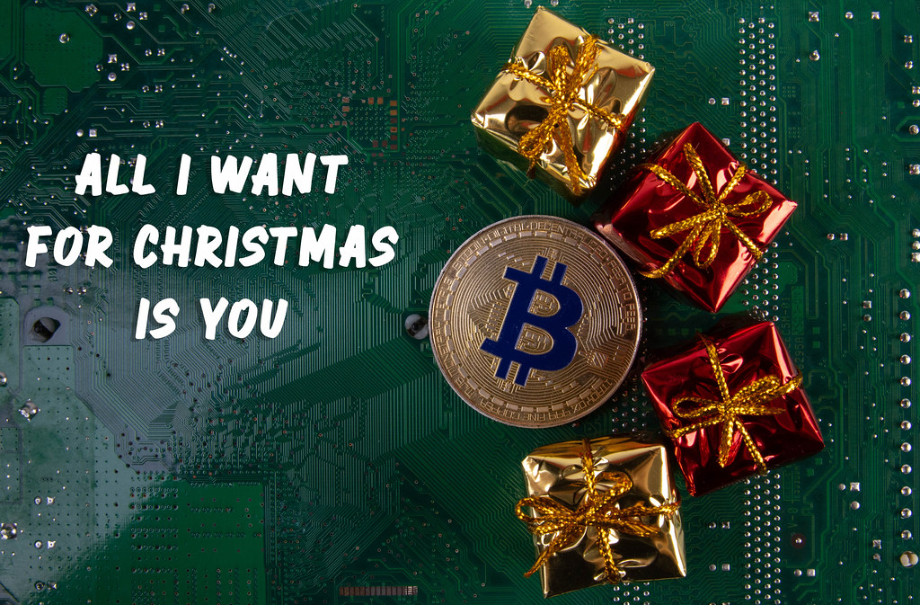 Bitcoin with gifts and All I want for Christmas is you text on computer motherboard