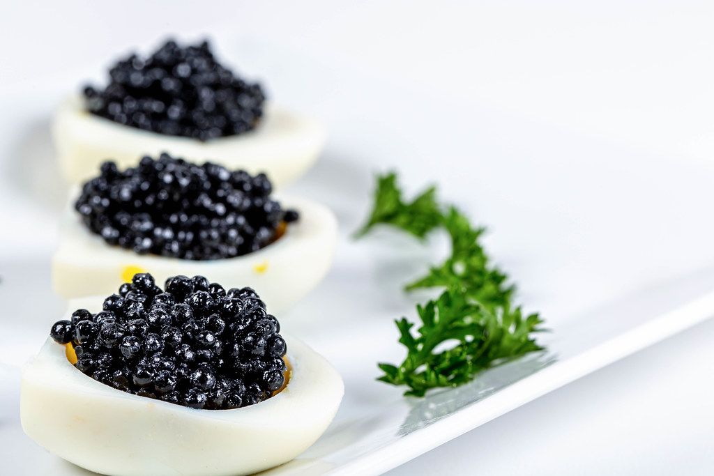Black caviar on a chicken eggs and parsley