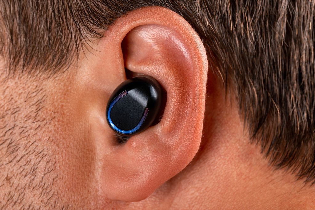 Black wireless earphone in a man