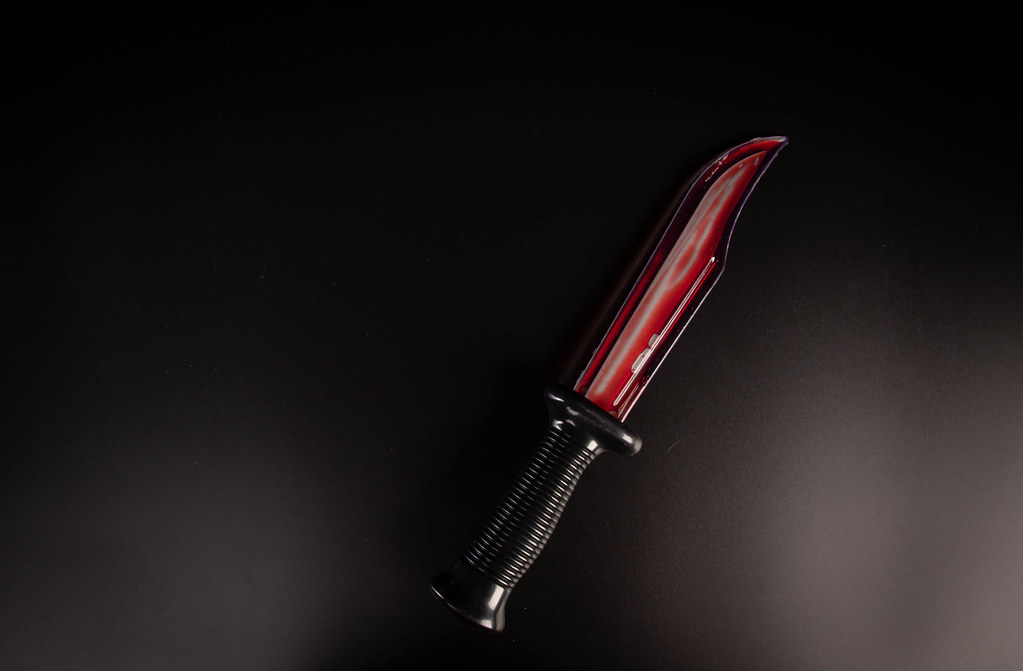 Bloody knife lies on a black background