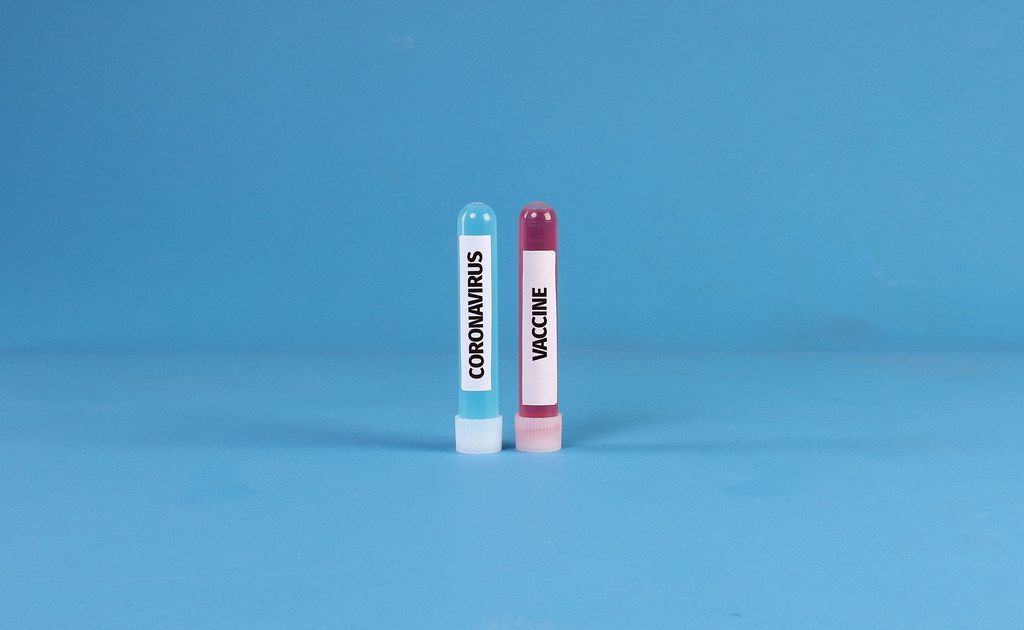 Blue and red test tubes with Coronavirus Vaccine text