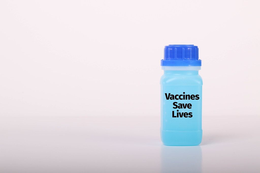 Bottle with blue fluid and Vaccines Save Lives text