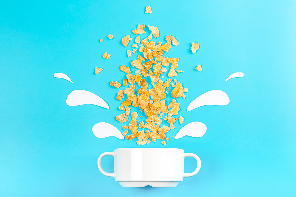 Breakfast background with scattered cornflakes on a blue background