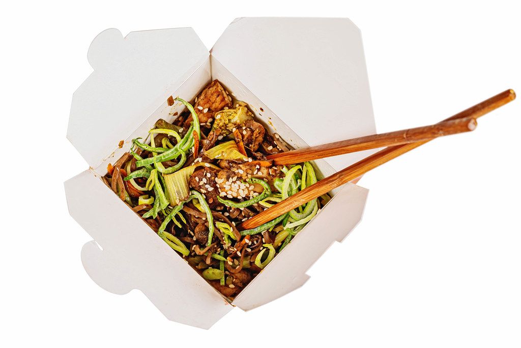 Buckwheat soba noodles with pork, vegetables, spicy sauce in a cardboard box