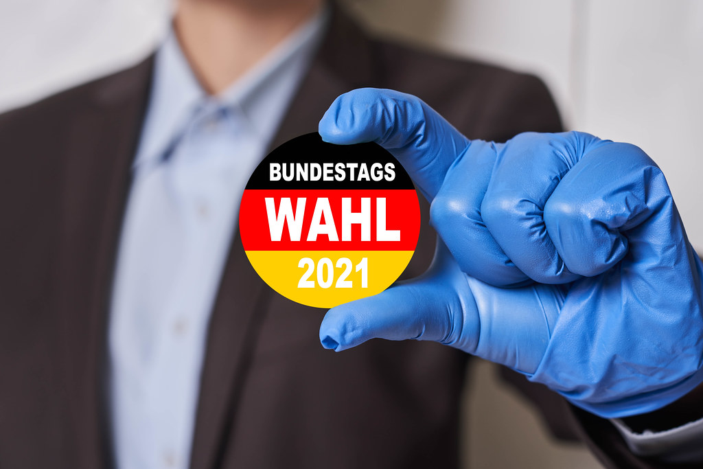 Bundestag elections badge with German flag in hands of a person in medical gloves