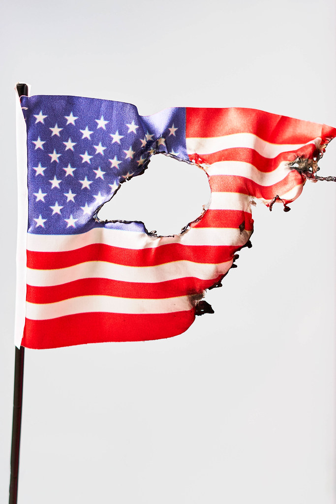 Burned US national flag against bright background