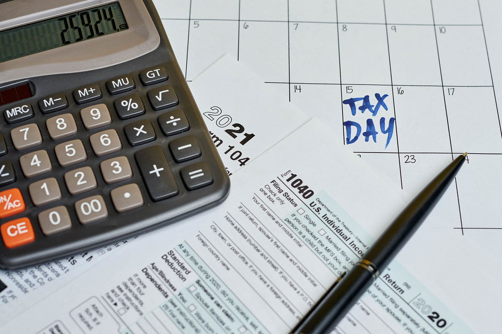 Business concept - tax form with pen and calculator on the calendar