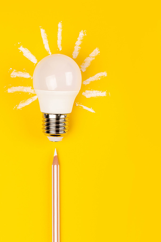 Business or creativity concepts, light bulb and pencil on yellow background