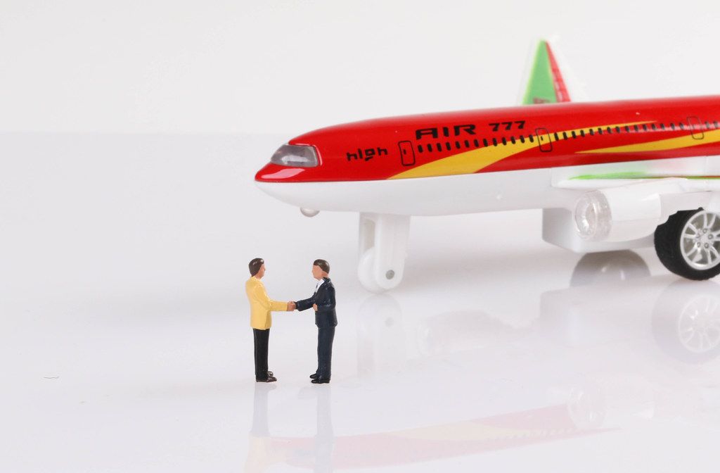 Businessman making agreement in front of airplane