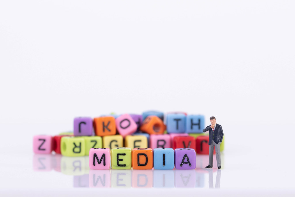 Businessman with colorful toy blocks with Media text