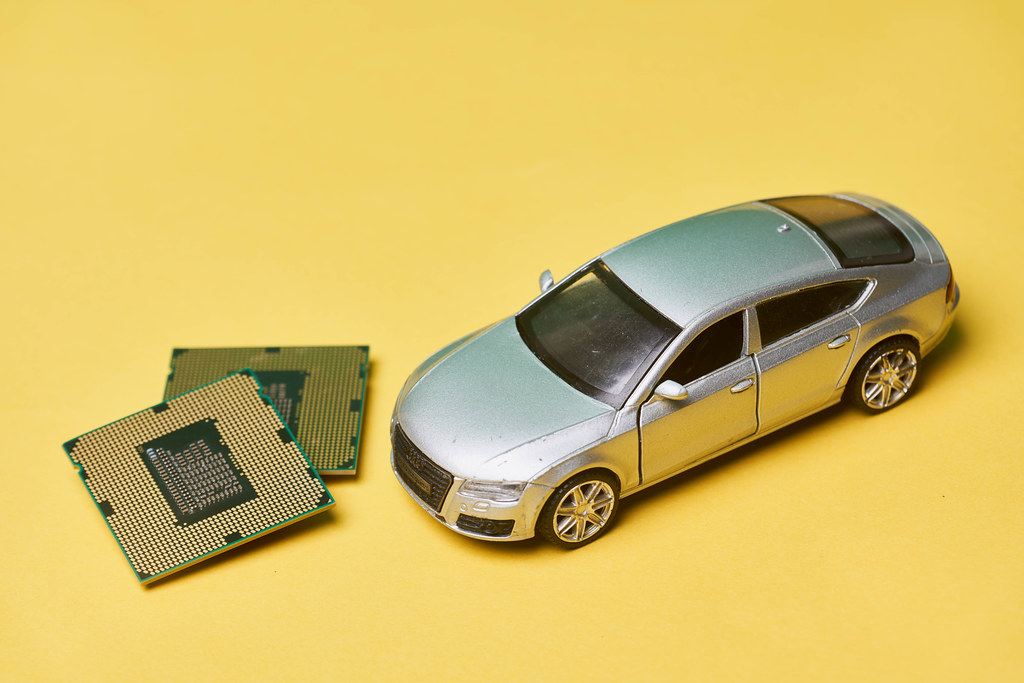 Car toy and cpu chips on yellow background