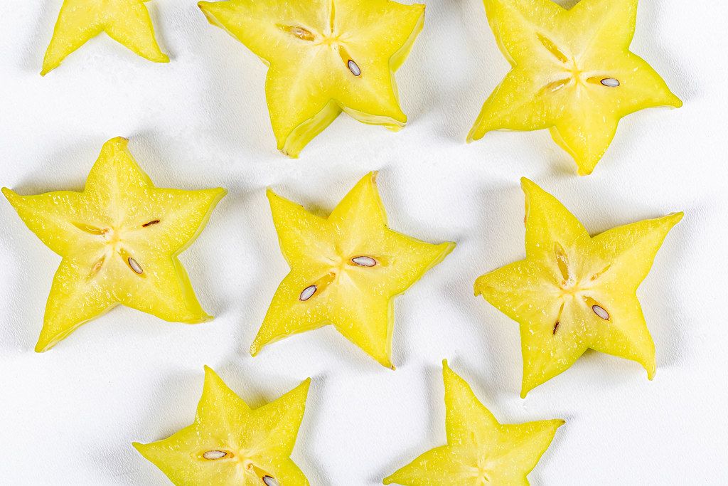 Carambola pieces-yellow stars on a white background, top view