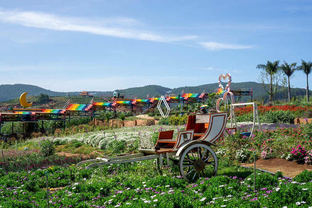 Carriage and Swing in a Flower Garden with Colored Stairs in the Background at Me Linh Coffee Garden in Da Lat, Vietnam