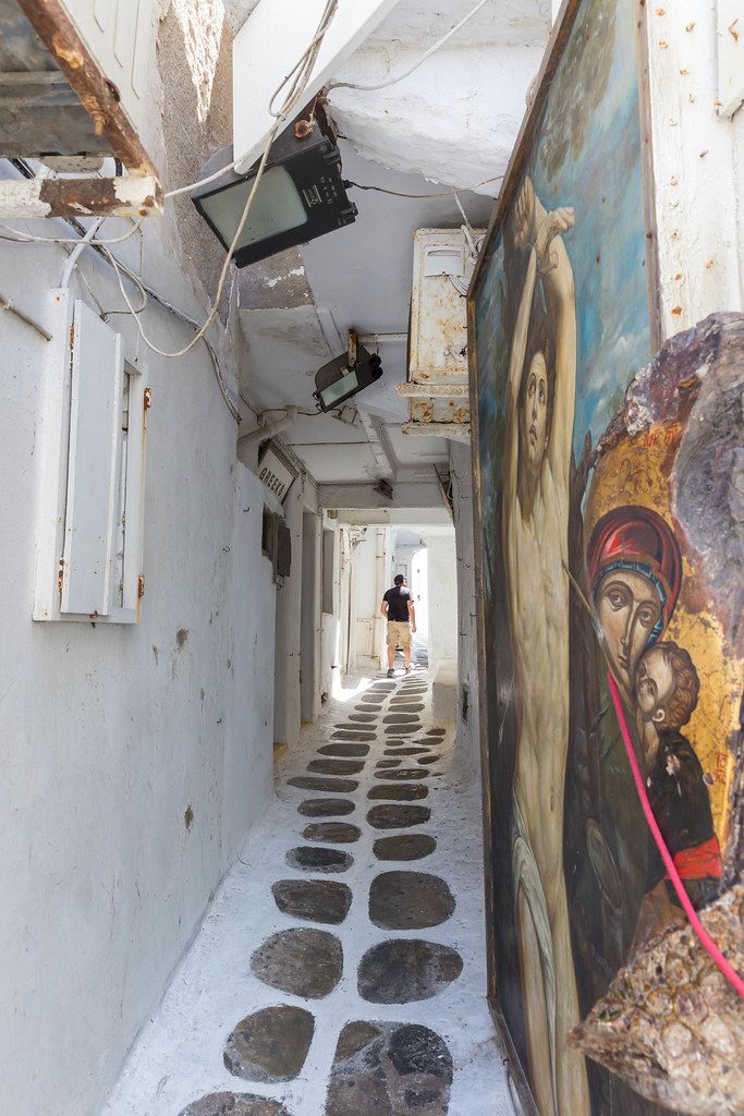 Christliche Gemälde in einer engen Gasse zwischen den weißen Häusern von Mykonos, Griechenland