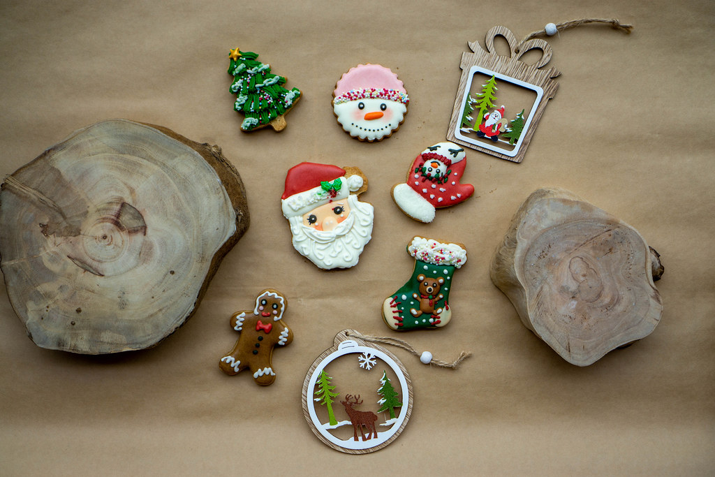 Christmas Background with different Gingerbread Christmas Cookies, Cut Tree Trunks and Wooden Christmas Decorations on a Baking Paper