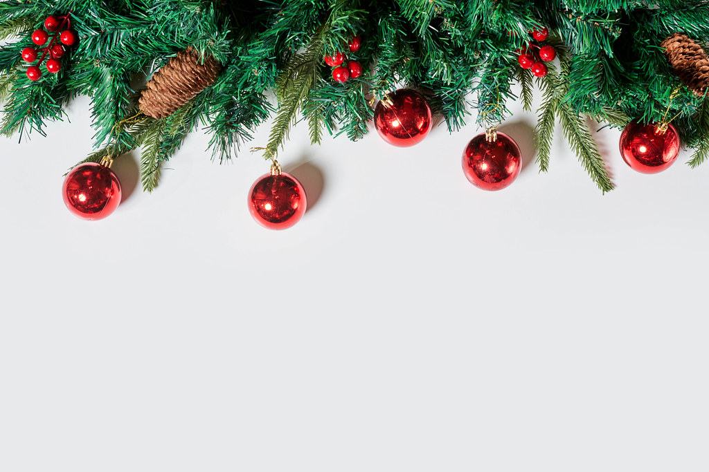 Christmas decoration - branch of christmas tree and balls on white background with space for text