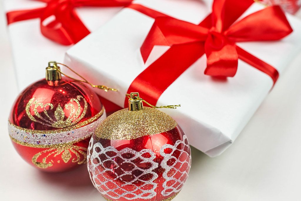 Christmas ornaments and beautiful present box bowed with red textile ribbon