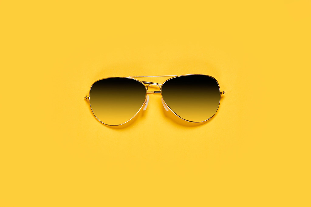 Classic sunglasses on bright yellow background