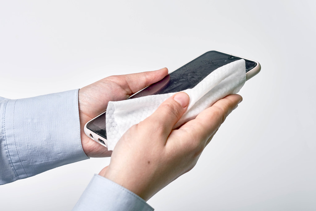 Cleaning smartphone surface with antibacterial wet wipe