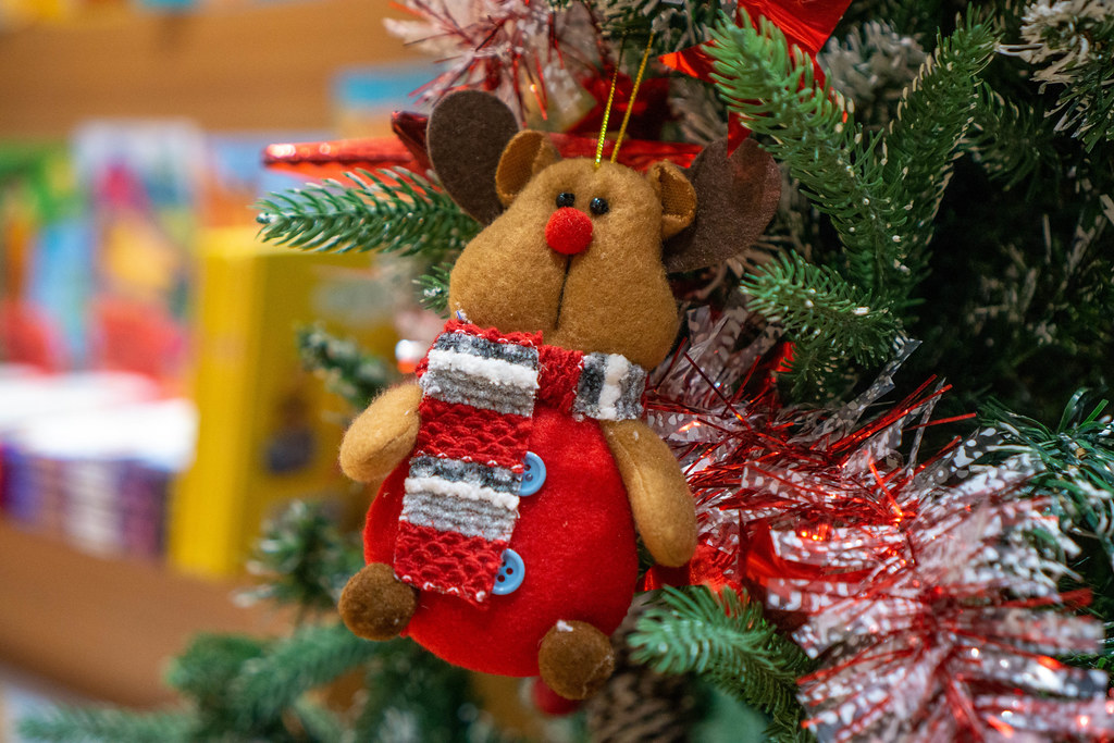 Close Up Bokeh Photo of Stuffed Animal Bear with Scarf on a Christmas Tree as Decoration