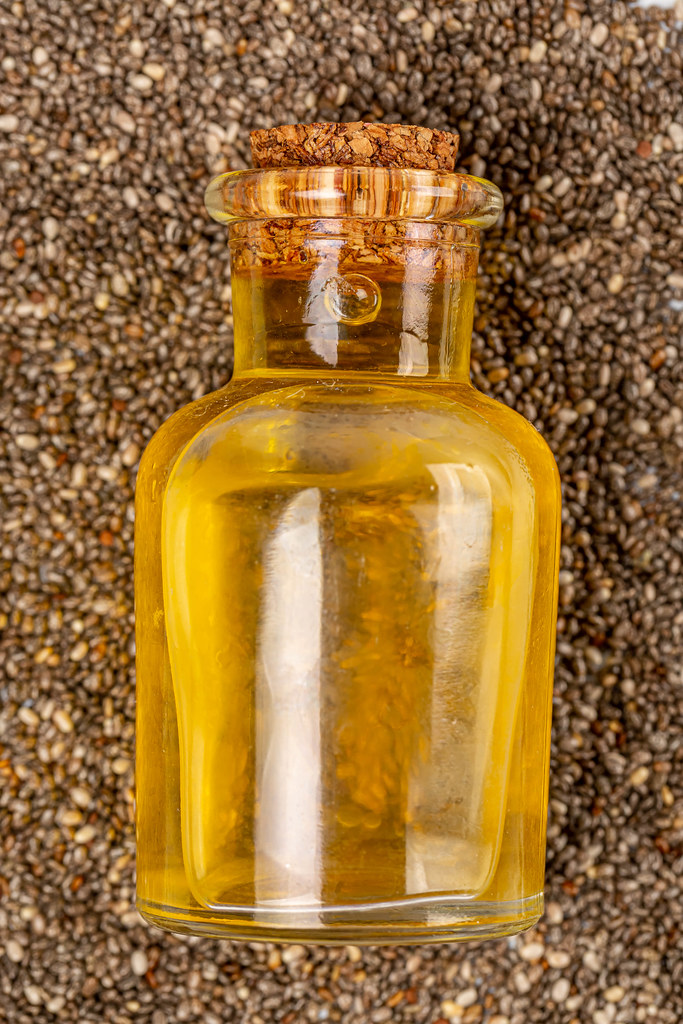 Close-up bottle with oil on a background of chia seeds