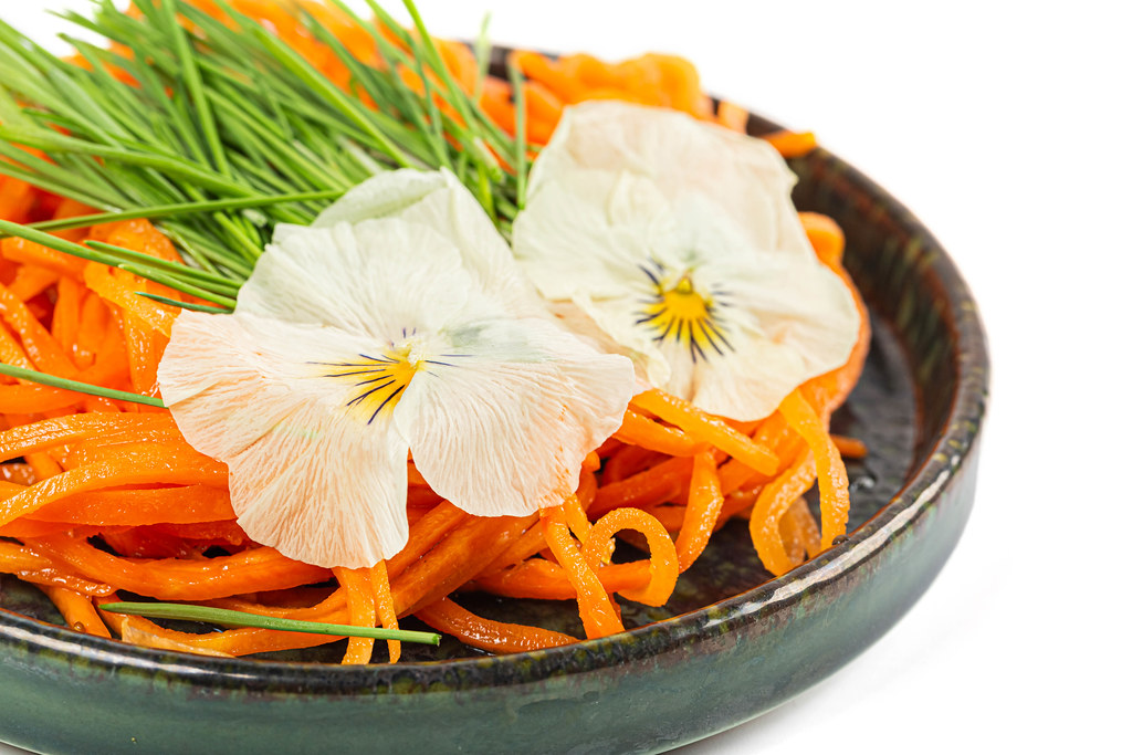 Close-up, carrot salad with wheat sprouts and flowers
