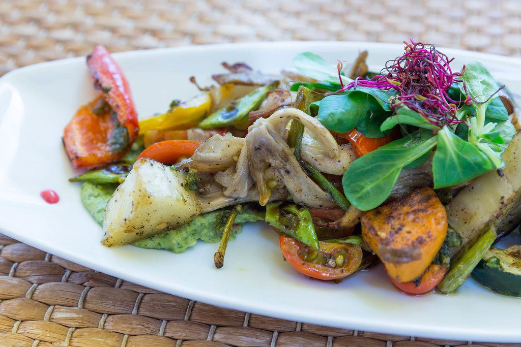 Close-up: fresh veggies and mushrooms on avocado sauce at restaurant Agapanto, Puerto de Sóller