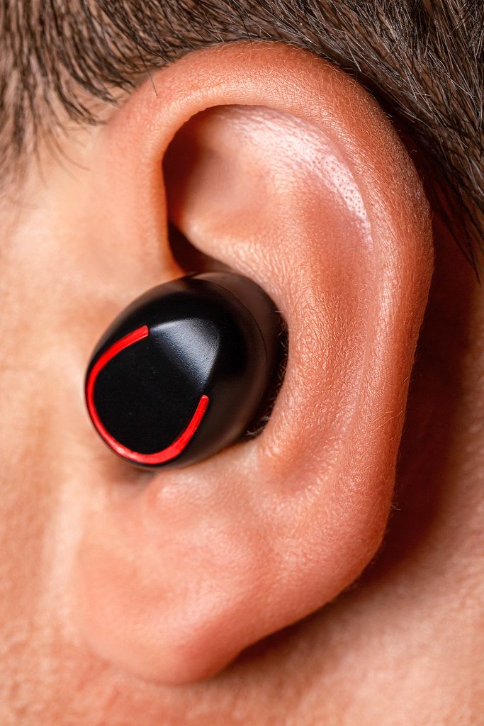 Close-up, male ear with wireless headphones
