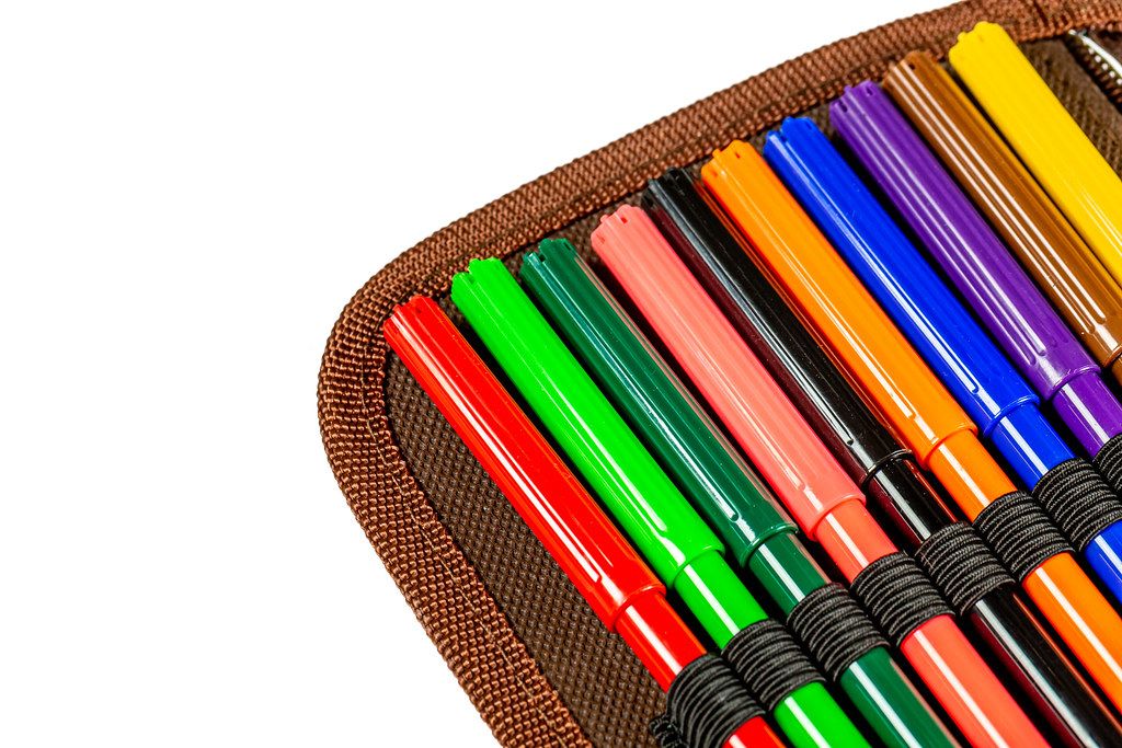 Close-up, multi-colored markers in a brown open pencil case